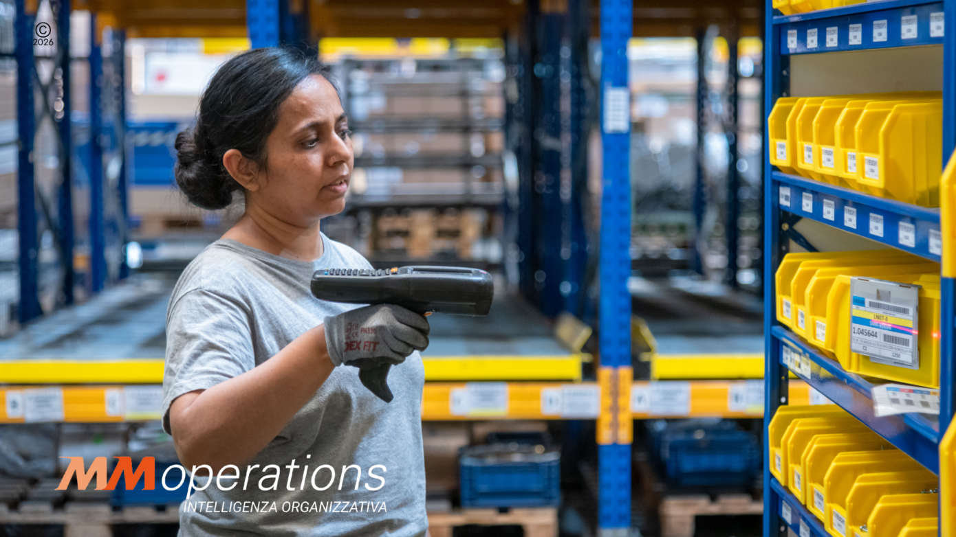Operatrice logistica impegnata nel picking per l'outbound omnicanale in un magazzino 3PL, utilizzando un terminale WMS per la gestione delle scorte e il fulfillment e-commerce.