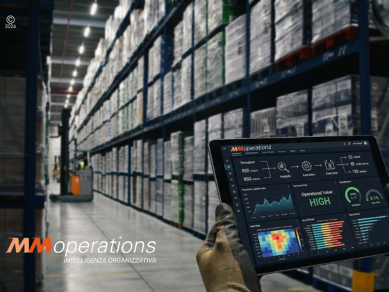 Operatore logistico che utilizza un tablet con dashboard di analisi dati in un magazzino automatizzato, rappresentando l'approccio data-driven di MM Operations alla consulenza logistica.