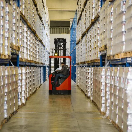 Scaffali pieni di conserve e passata di pomodoro in magazzino food